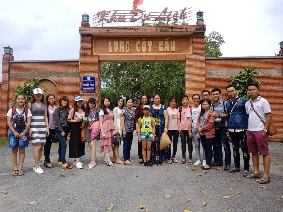 Du khách chụp ảnh kỷ niệm tại cổng chào của vườn sinh thái Lung Cột Cầu