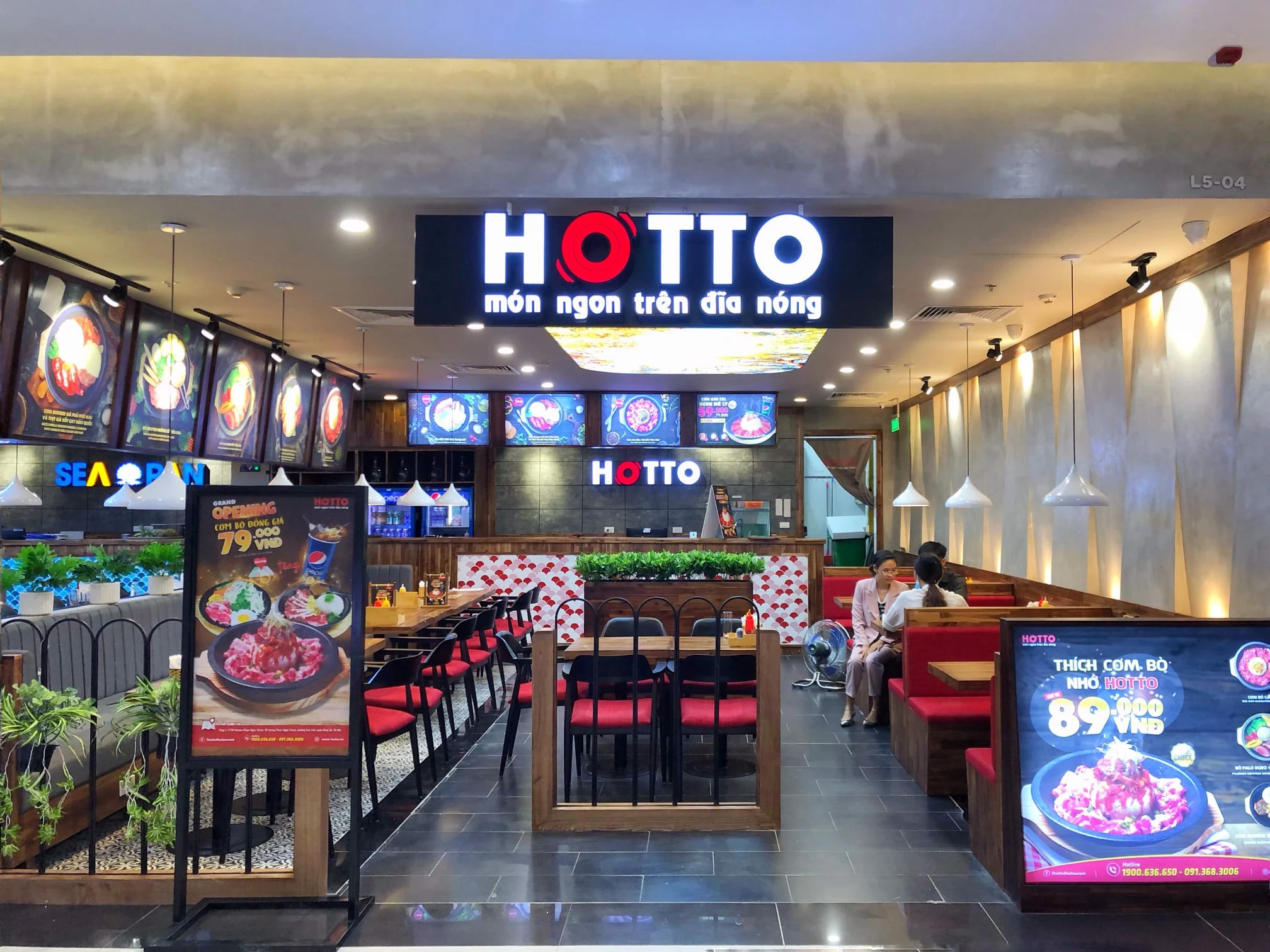 Không gian cửa hàng Hotto với biển hiệu Hotto món ngon trên dĩa nóng